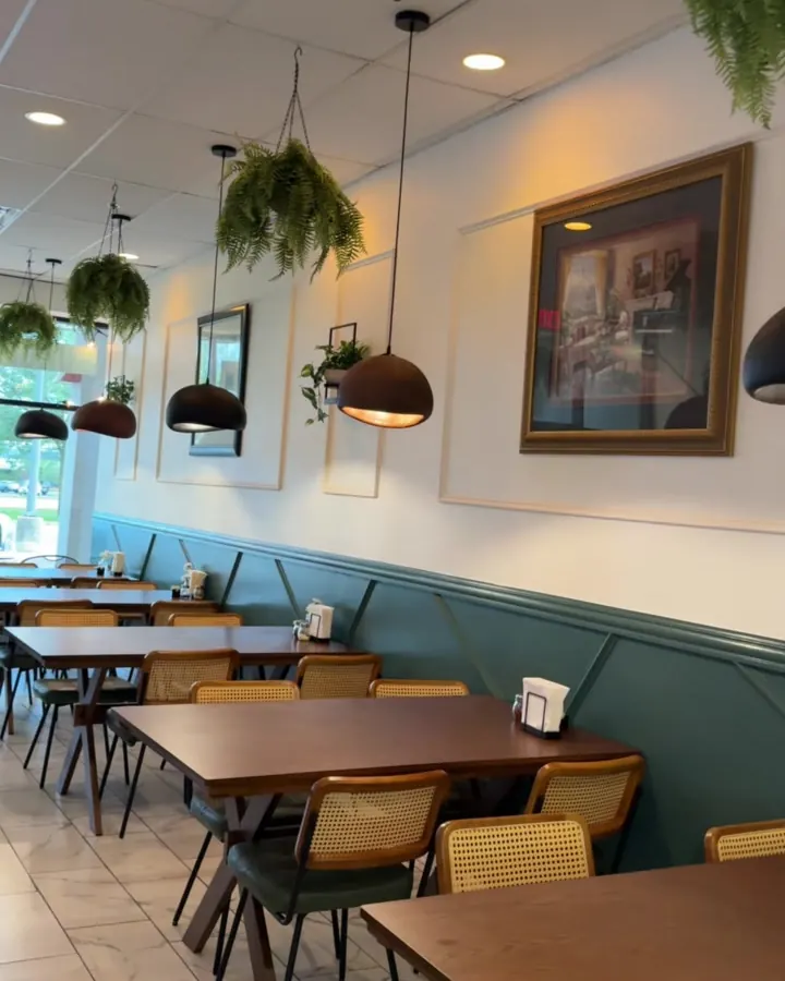Jan's dining room: wood tables, cane-back chairs, green wainscoting and hanging ferns